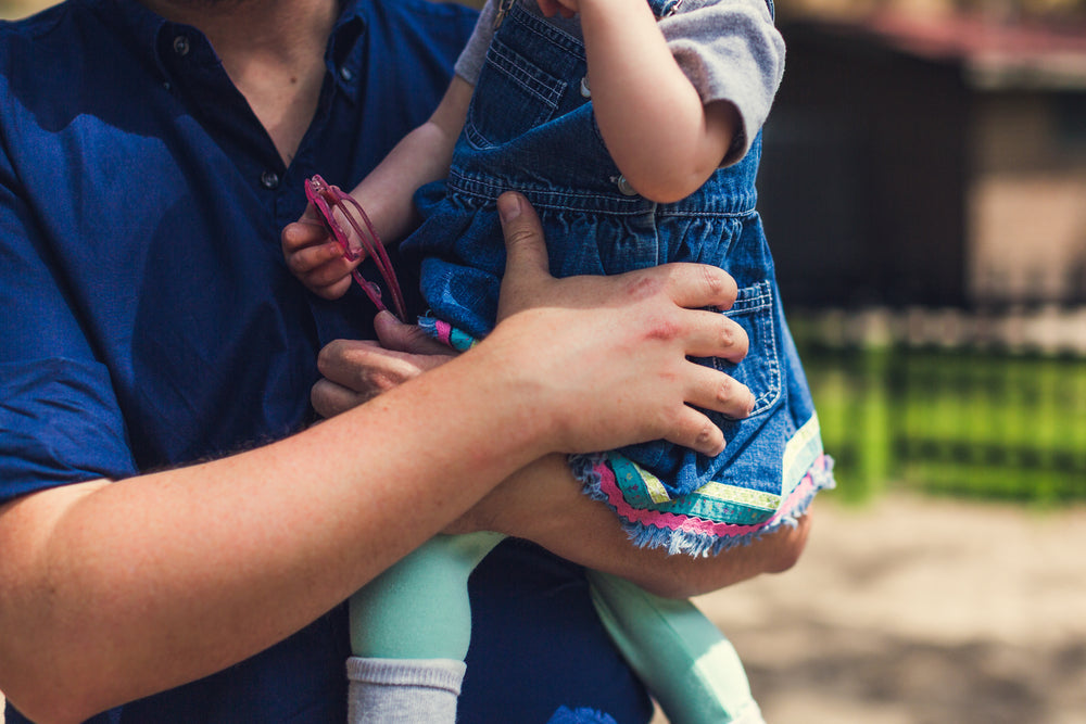 Father holding a smiling baby girl in his arms