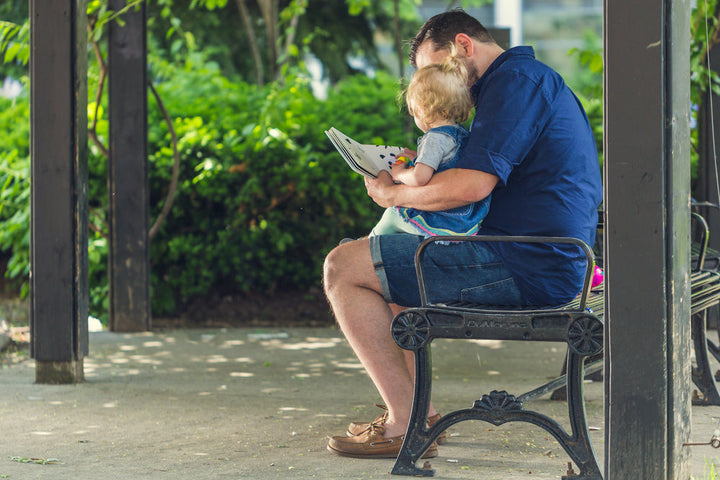 Father reading a book to his young daughter together
